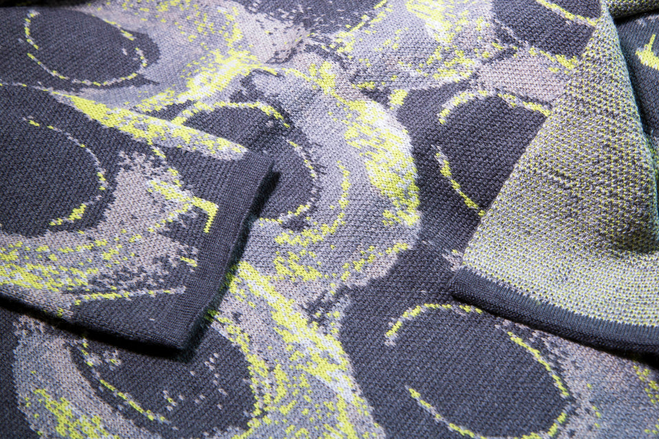closeup up finely knitted Hoswick Paint jacket - curvilinear motifs in shaded greys with yellow highlights