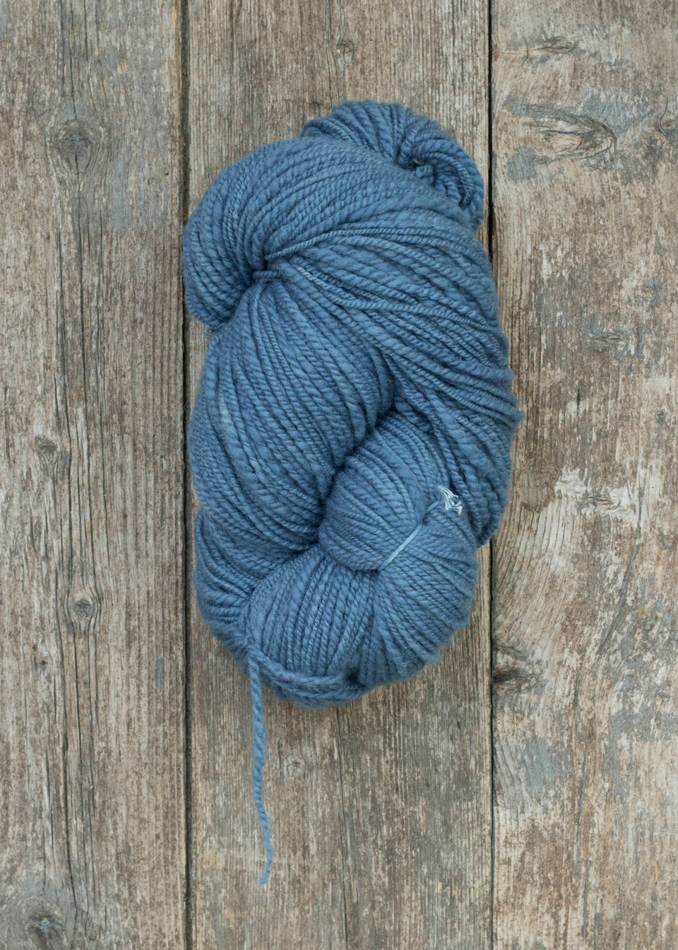 handspun, hand-dyed indigo yarn. polwarth and shetland blend. shown wound into a large skein. 