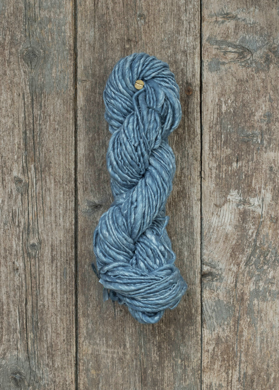 handspun, hand-dyed skein of yarn in silvery indigo. the yarn is Silk/Kid Mohair/Bluefaced Leicester mix.