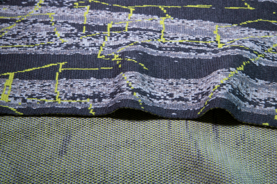 close up of scarf in greys with highlight linear patterning in yellow. reverse speckle pattern also shwon.